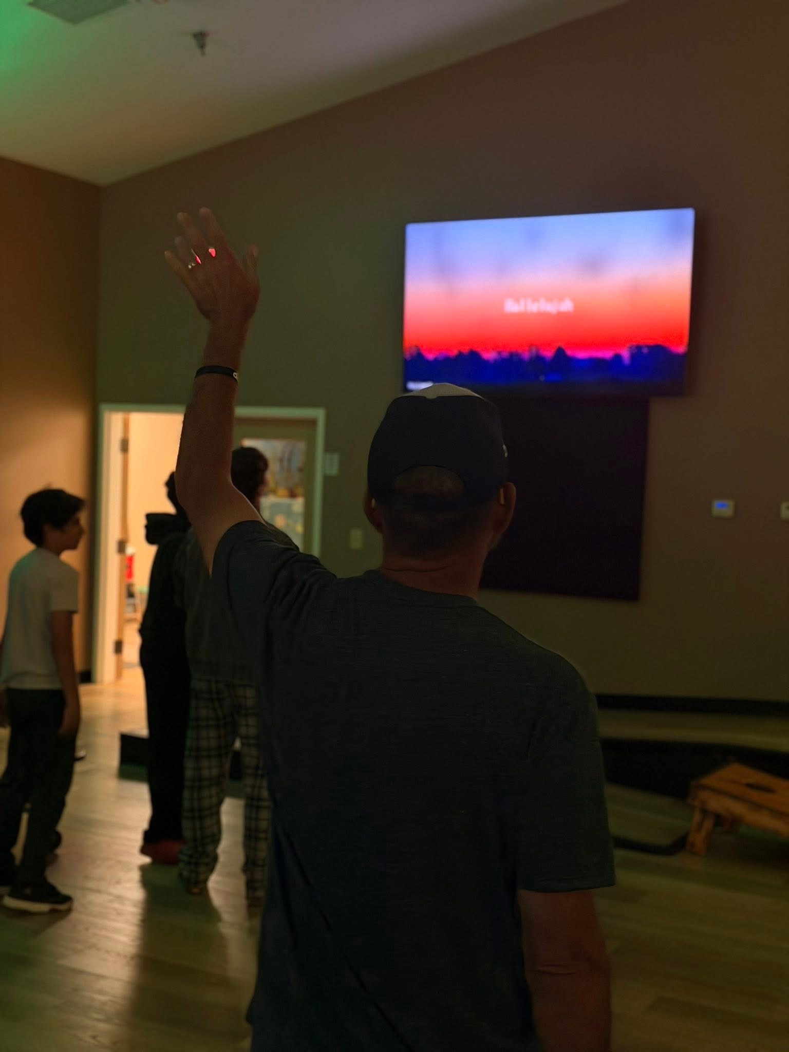 Student raising a hand during worship